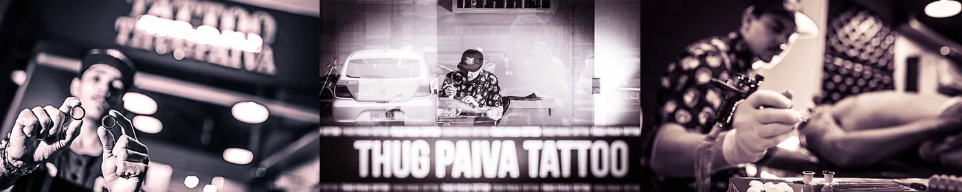 Thug Paiva sorrindo sob o letreiro do estúdio, segurando dois anéis