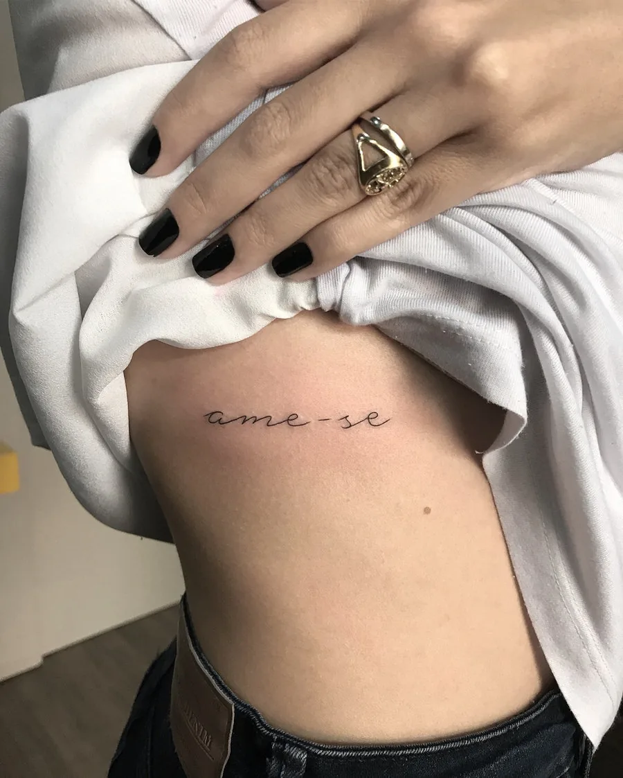 Frase curta em letra fina na lateral das costelas